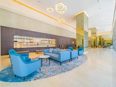 a hotel lobby with blue couches and a table at Charming Tropical Apartment Minutes To Dubai Mall in Dubai