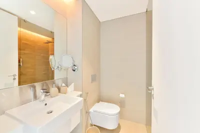 a bathroom with a sink and a toilet and a mirror at Premium 2+1 BR condo in the heart of Bluewaters Island in Dubai
