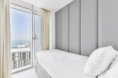 a bedroom with a bed and a large window at Premium 2+1 BR condo in the heart of Bluewaters Island in Dubai