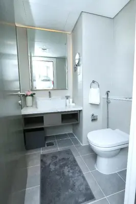 a bathroom with a toilet and a sink and a mirror at DAMAC MAISON PRIVE in Dubai