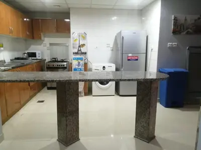 a kitchen with a granite counter top and a refrigerator at AlBarsha 1 Hostel by PHM in Dubai