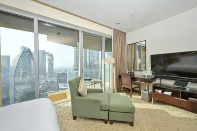 a living room with a television and a couch and a desk at FAHH - Spacious Studio in Emaar Fashion Avenue in Dubai