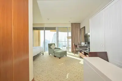 a hotel room with a bed and a chair and a desk at FAHH - Spacious Studio in Emaar Fashion Avenue in Dubai
