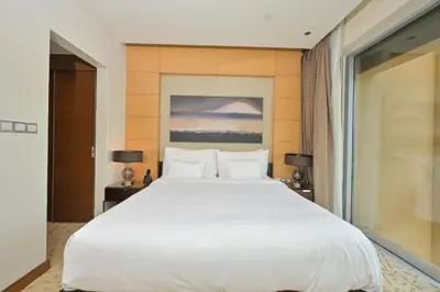 a large white bed in a room with a window at FAHH - Spacious Studio in Emaar Fashion Avenue in Dubai
