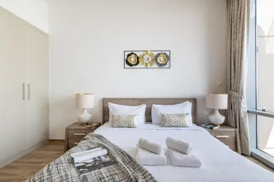 a bedroom with a large white bed with pillows at The Smart Concierge - Amna Tower in Dubai