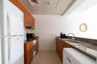 a kitchen with a sink and a refrigerator at GuestReady Holiday Homes - The Green Scape in Dubai