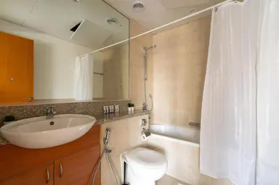 a bathroom with a sink and a toilet and a mirror at GuestReady Holiday Homes - The Green Scape in Dubai