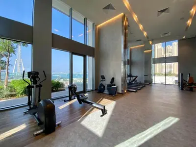 a gym with treadmills and ellipticals in a building with windows at Keysplease Fascinating SeaViews! 2 B/R Luxury Apt 52/42, Marina in Dubai