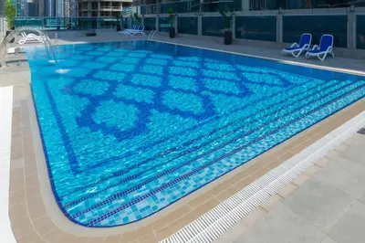 a large swimming pool with blue water in a building at Spacious Apartment with Balcony Near Dubai Mall in Dubai
