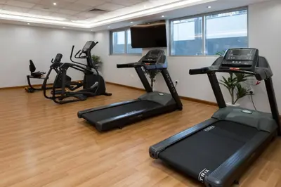 a gym with treadmills and exercise bikes in a room at Spacious Apartment with Balcony Near Dubai Mall in Dubai