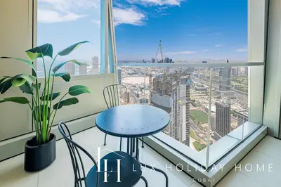 a blue table and chairs in a room with a window at LUX The Sky View Suite Dubai Marina in Dubai