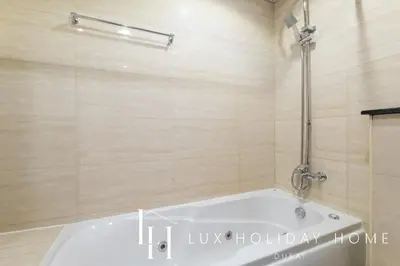 a bath tub in a bathroom with a shower at LUX The Sky View Suite Dubai Marina in Dubai