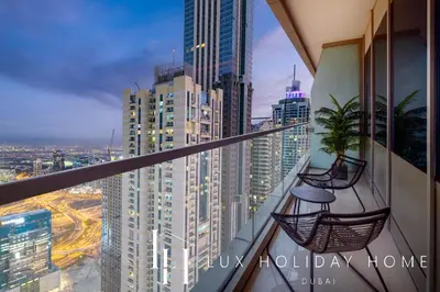 a balcony with two chairs and a view of a city at LUX The Sky View Suite Dubai Marina in Dubai