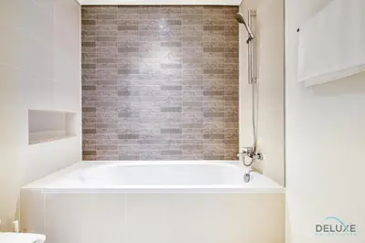 a bath tub in a bathroom with a brick wall at Idyllic 1BR at Sunrise Bay Tower 1 Emaar Beachfront Dubai Marina by Deluxe Holiday Homes in Dubai
