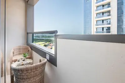 a balcony with two chairs and a large window at Frank Porter - Capital Bay Tower B in Dubai