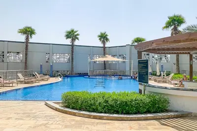 a large swimming pool with palm trees in a building at Frank Porter - Capital Bay Tower B in Dubai