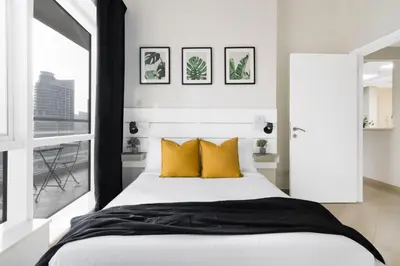 a bedroom with a large bed with yellow pillows at GuestReady - Jumeirah Skyline Apartment in Dubai