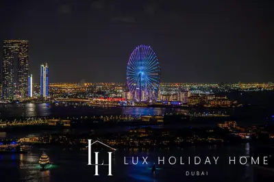 a large ferris wheel in a city at night at LUX Iconic Views at The Palm Tower Suite 2 in Dubai