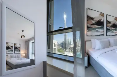 a bedroom with a window with a view of the city at Signature 2BR with Burj Khalifa & Fountain View in Dubai