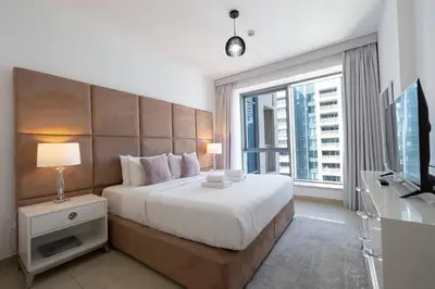 a bedroom with a large bed and a large window at Signature 2BR with Burj Khalifa & Fountain View in Dubai
