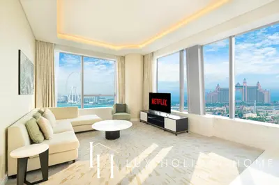 a living room with a couch and a tv at LUX Iconic Views at The Palm Tower Suite 1 in Dubai
