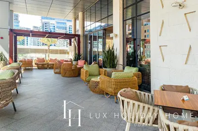 a restaurant with wicker chairs and tables in a building at LUX Iconic Views at The Palm Tower Suite 1 in Dubai