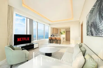 a living room with a couch and a tv at LUX Iconic Views at The Palm Tower Suite 1 in Dubai