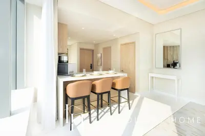 a kitchen with a bar with stools in it at LUX Iconic Views at The Palm Tower Suite 3 in Dubai