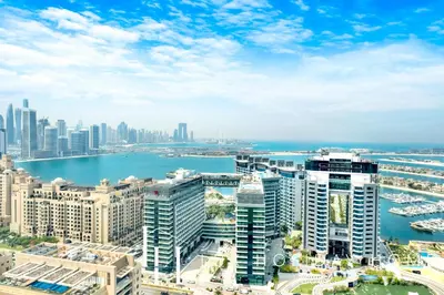 an aerial view of a city with a body of water at LUX Iconic Views at The Palm Tower Suite 3 in Dubai
