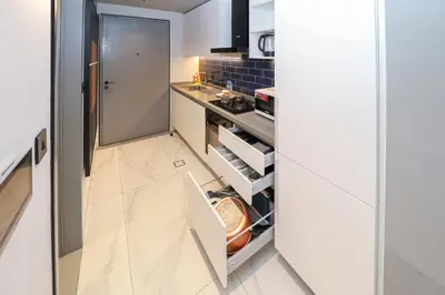 a small kitchen with white cabinets and a counter at Luxury MAG 318 Studio Near Dubai Mall in Dubai