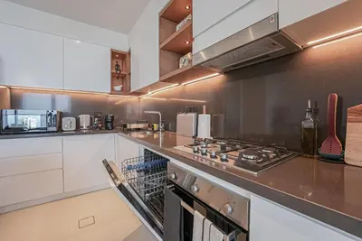 a kitchen with white cabinets and a stove top oven at Modern 2BR High Floor Haven in Vida Dubai Marina in Dubai