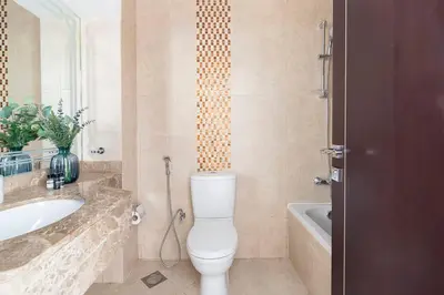 a bathroom with a toilet and a sink and a tub at Frank Porter - Siraj Tower in Dubai