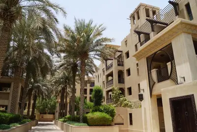 a building with palm trees in front of it at Burj Khalifa view, birds chirping, cozy and stylish in Dubai