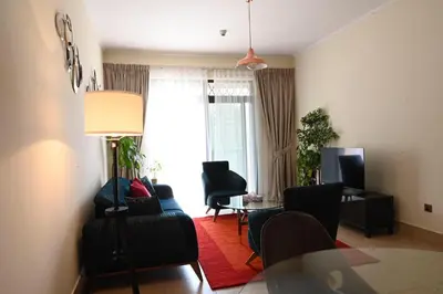 a living room with a couch and chairs and a window at Burj Khalifa view, birds chirping, cozy and stylish in Dubai