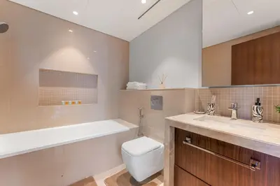 a bathroom with a toilet and a tub and a sink at boulevard point view in Dubai