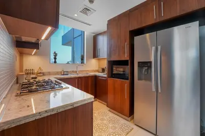 a kitchen with wooden cabinets and a stainless steel refrigerator at boulevard point view in Dubai