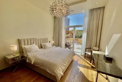 a bedroom with a bed and a chandelier at Tiara Residence - Palm Jumeirah Dubai in Dubai
