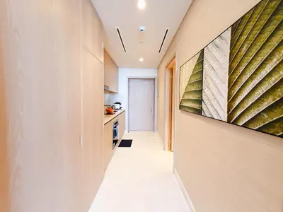 a hallway leading to a kitchen with a painting on the wall at ORION in Dubai