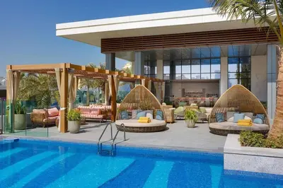 a resort with a swimming pool with couches and a pool at ORION in Dubai