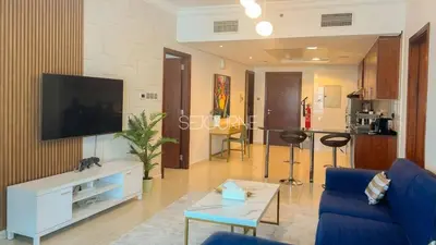 a living room with a blue couch and a tv at LV38 - Elegant 2BHK in Lake View Tower in Dubai