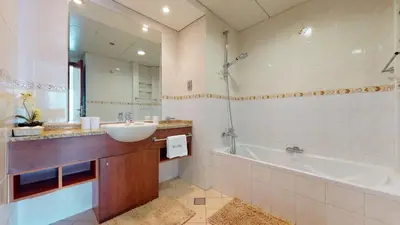 a bathroom with a sink and a bath tub and a sink at LV38 - Elegant 2BHK in Lake View Tower in Dubai