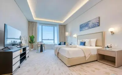 a large bedroom with a large bed and a television at Palm Tower Palm Jumeirah Dubai in Dubai