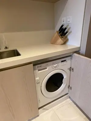 a kitchen with a washing machine and a sink at Palm Tower Palm Jumeirah Dubai in Dubai