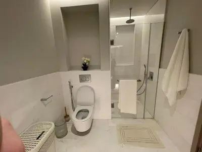 a small bathroom with a toilet and a shower at Palm Tower Palm Jumeirah Dubai in Dubai
