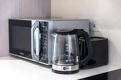 a black microwave and a tea kettle on a counter at Palm Tower Palm Jumeirah Dubai in Dubai