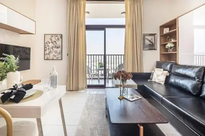 a living room with a black leather couch and a table at Frank Porter - Starz by Danube in Dubai