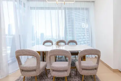 a dining room with a table and chairs at Vacay Lettings - High floor Burj Khalifa & Fountain view 3 bed in Dubai
