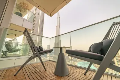 a balcony with two chairs and a table in a building at Luxury 3BR with Burj Khalifa Views, Pool, Gym, and Free Parking in Dubai