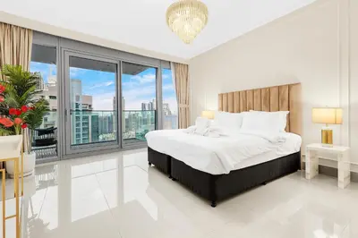 a bedroom with a large bed and a large window at Luxury 3BR with Burj Khalifa Views, Pool, Gym, and Free Parking in Dubai