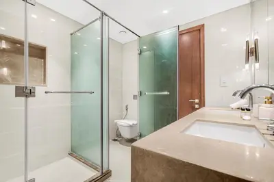 a bathroom with a shower and a sink and a toilet at Luxury 3BR with Burj Khalifa Views, Pool, Gym, and Free Parking in Dubai